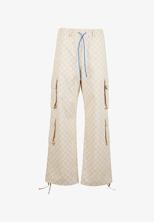 Bežid värvides cargo-püksid, millel on korduv logokujundus, laiad säärted, elastne vöökoht sinise nööriga ja mitmed küljetaskud.