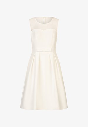 White sleeveless dress with a sweetheart neckline, featuring a sheer panel and a pleated skirt. Includes a bow accent at the waist.