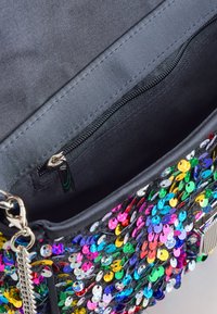 Rankų darbo rankinė su blizgančiomis akutėmis, juodo audinio pagrindu, su blizgiu užtrauktuku, spalvotomis akutėmis ir sidabro spalvos detalėmis.