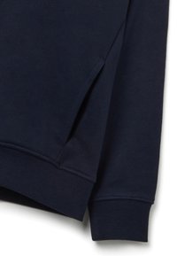 Felpa navy con polsini e orlo a coste, dotata di tasca laterale e materiale in morbido misto cotone, texture liscia con dettagli minimi.