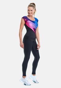 Fitted workout top with blue and pink galaxy pattern, black leggings, and white athletic shoes. Smooth fabric, cap sleeves, and gathered details.