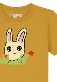 Gele katoenen t-shirt met een schattig, cartoonachtig konijn met grote ogen en roze oren, omringd door groen gras en kleurrijke bloemen.