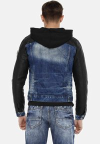 Denim and black leather jacket with a hood, featuring a fitted design, contrasting materials, and a distressed blue wash on the back.