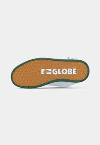 Roheline ja valge spordijalatsite tald, millel on tekstureeritud kummipind, millel on teemantmustrites ja "GLOBE" logo julgete valgete tähtedega.
