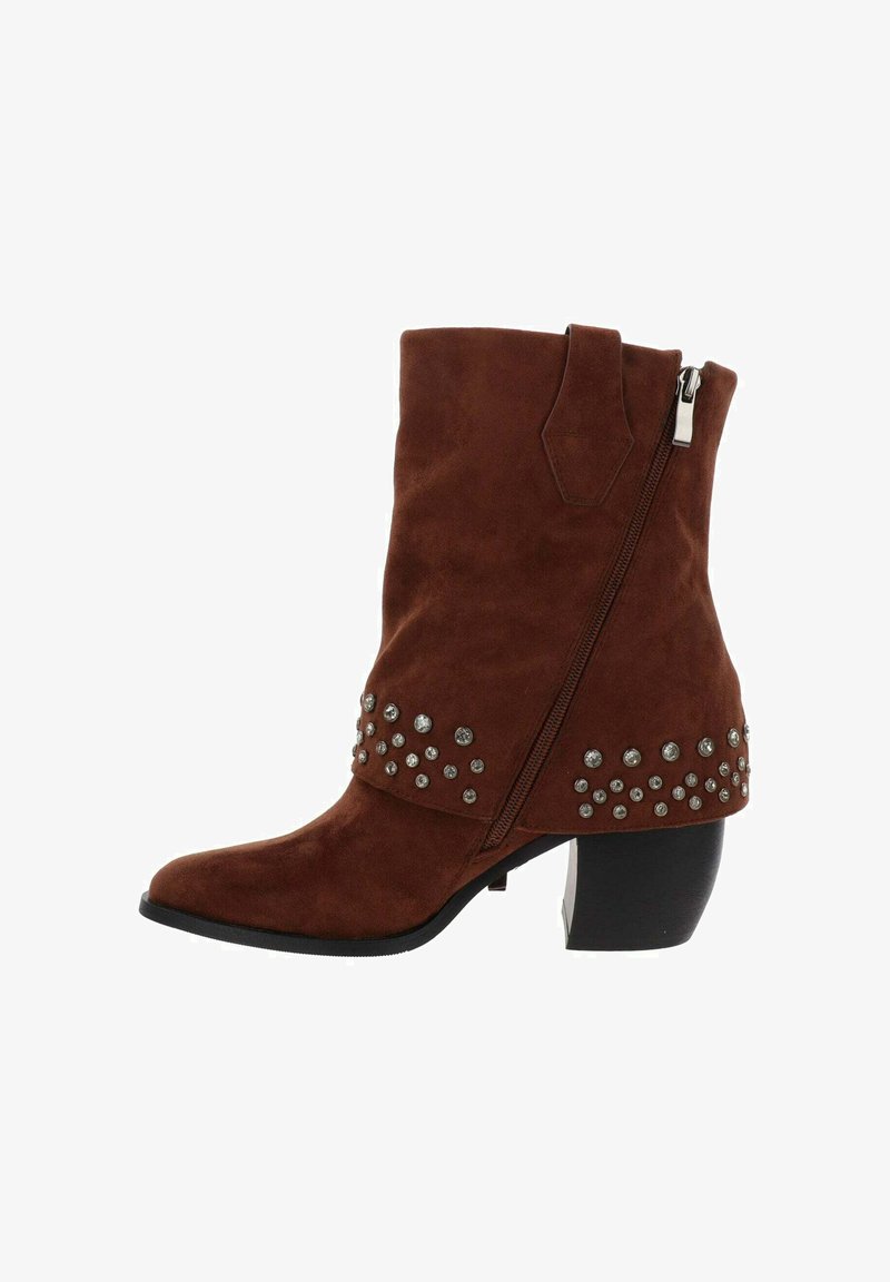 Botas de tobillo de ante marrón con punta afilada, cierre de cremallera y un tacón grueso. Decoradas con tachuelas plateadas a lo largo del tobillo.