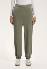 Kalhoty se zvýšeným pasem v olivově zelené barvě z měkké tkaniny; elastické manžety na kotnících, boční kapsy, volný střih s pohodlným pasem.