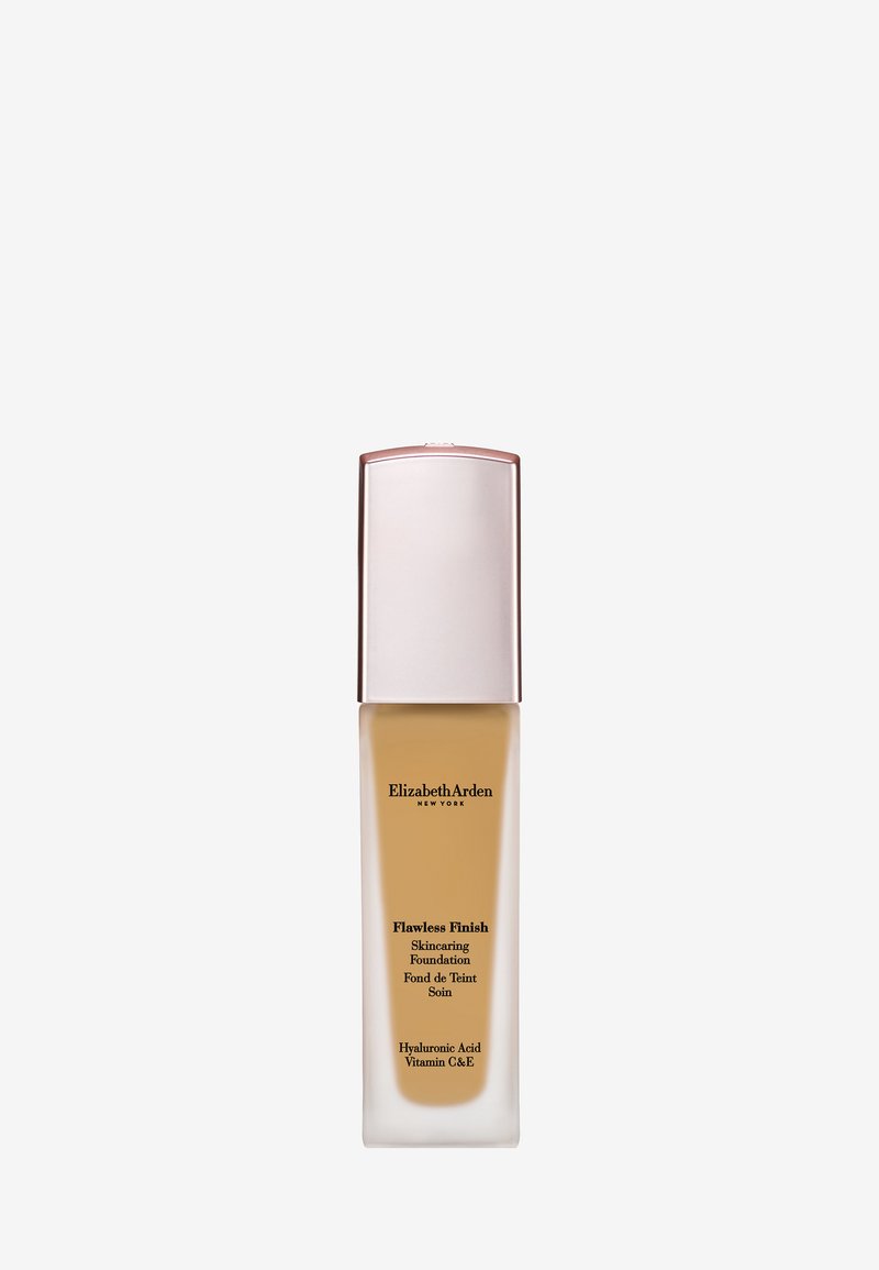 Grande bouteille rectangulaire en verre avec fond de teint liquide beige, bouchon argenté, étiquetée Elizabeth Arden Flawless Finish avec acide hyaluronique et vitamines C et E.
