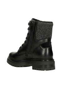Schwarzer Lederkampfstiefel mit dicker Sohle, seitlichem Reißverschluss, Schnürsenkeln und grauem Strickbund um den Knöchel, aus einer äußeren Perspektive betrachtet.