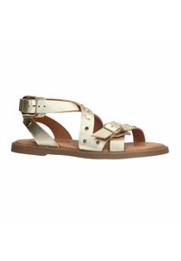 Gouden metallic sandalen met platte zolen, voorzien van gekruiste banden, studs en een verstelbare enkelsluiting. Glad leren textuur.