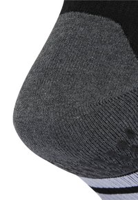 Zwarte en grijze sok met een textuur, gebreid ontwerp, een verstevigde hak, rubberen grip stippen en contrasterende witte strepen aan de bovenkant.