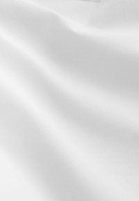 Gluda balta auduma ar maigām krokām un mīkstu tekstūru, kas rada smalkas ēnas un izgaismojumus uz virsmas.