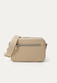 Sac en bandoulière beige en matériau texturé, avec une poche zippée à l'avant, de forme rectangulaire et doté d'une sangle en tissu robuste.