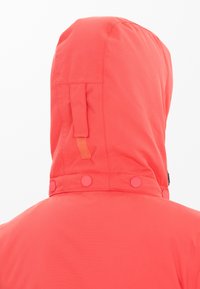 Koralle wasserfeste Jacke mit Kapuze, Druckknöpfen am Hals und einer glatten, strukturierten Oberfläche. Verstellbare Kapuze mit einem Detailstreifen.