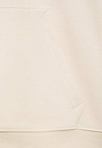 Beige sweatshirt stof met een voorzak en een diagonale naad. Gladde textuur met ribbelmanchetten en onderrand. Minimalistisch ontwerp.