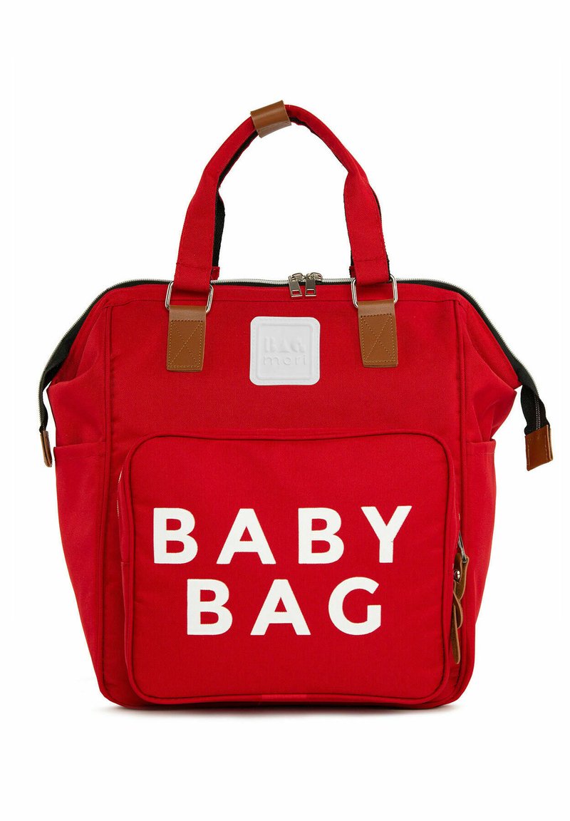 Red fabric baby bag with a front pocket featuring bold white text "BABY BAG." Brown leather accents on handles and zipper. Zippered closure.