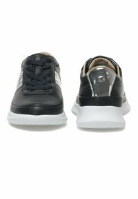 Black leather sneakers featuring a textured finish, smooth black accents, white sole, and contrasting silver stripe detail on the sides.