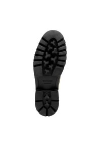 Semelle en caoutchouc noir avec des motifs de profondeur, dotée d'un talon courbé et d'un marquage en relief. Conçue pour l'adhérence et la durabilité.