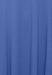 Blauer Stoff mit einer strukturierten, leicht zerknitterten Oberfläche. Das Material wirkt leicht und fällt sanft, wodurch subtile Falten entstehen.