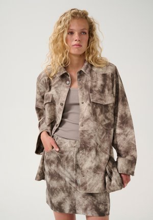 Brown and beige tie-dye shirt jacket with snap buttons, two chest pockets, and a matching skirt. The fabric has a soft, textured appearance.