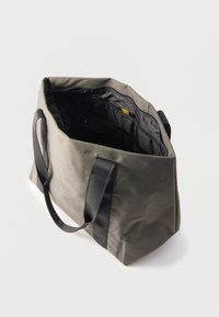 Γκρι τσάντα ώμου με μαύρες λαβές, ανοιχτό επάνω φερμουάρ και πολλαπλές εσωτερικές θήκες σε απλό λευκό φόντο.