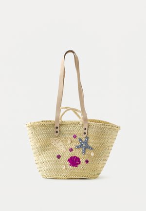Sac cabas en paille tressée avec deux anses en cuir beige, décoré de coquillages brodés, d’étoiles de mer et de petits accents de coquillages violets et blancs.