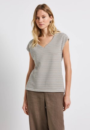 Top de manga corta a rayas en crema y topo, con un escote en V y un corte relajado. Textura suave con patrones sutiles. Combinado con pantalones marrones holgados.