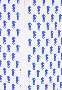 Tessuto bianco con un motivo ripetuto di cavallucci marini blu. Il materiale ha una consistenza liscia con cuciture visibili lungo il centro.