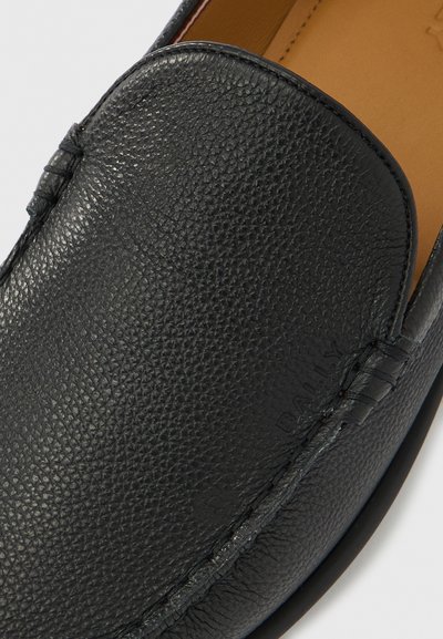 Μαύρο slip-on μοκασίνι από δέρμα με κοκκώδη υφή, εμφανείς ραφές και ταμπά εσωτερική επένδυση, εμφανίζει ανώτερο και πλαϊνό λεπτομέρεια.