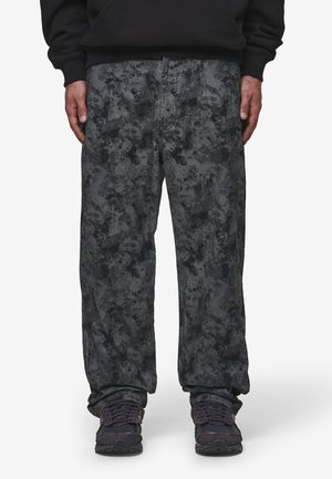 Pantalones de pierna ancha hechos de denim texturizado en tonos de gris oscuro con un patrón salpicado; se observan la bragueta delantera y los bolsillos laterales.