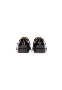 Scarpe in pelle verniciata nera con un design elegante e arrotondato e una suola bassa e liscia. Presentano una cucitura sottile lungo il retro per un tocco di dettaglio in più.