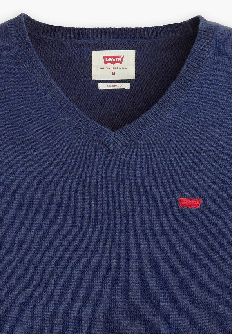 Marineblaues V-Ausschnitt-Pullover aus Strickstoff, mit einem roten Levi's-Logo auf der Brust sowie einem gerippten Kragen und Bündchen.
