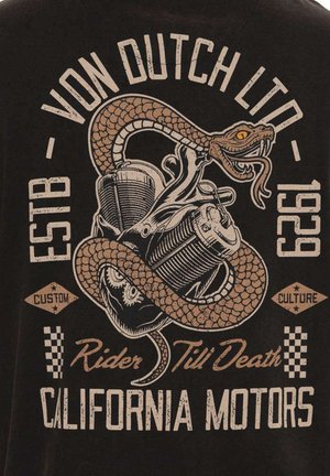 T-shirt noir avec un design graphique de style vintage. Image centrale d'un serpent enroulé autour de moteurs de moto, avec des accents beiges et orange.