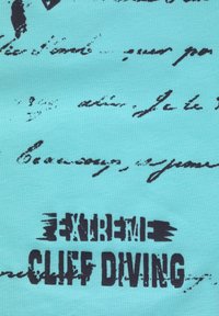Tela turquesa con escritura en cursiva negra y texto en negrita desgastado que dice "CLIFF DIVING EXTREMO" centrado en la superficie.