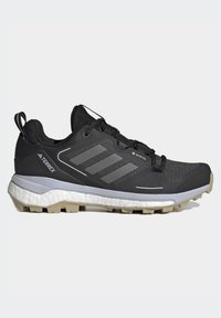 Sorte joggesko med mesh-overflate, grå detaljer, og tre striper. Har en teksturert såle og en polstret mellomsåle for komfort.