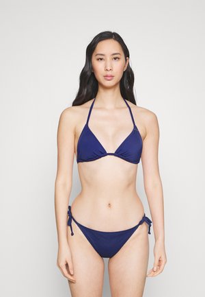 Navy blue bikini set featuring a triangle top with thin straps and a bottom with side ties. Smooth texture, simple design, and monochromatic color.