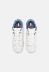 Paire de baskets en cuir blanc avec lacets blancs et doublure intérieure bleu clair, vues de dessus sur un fond uni.