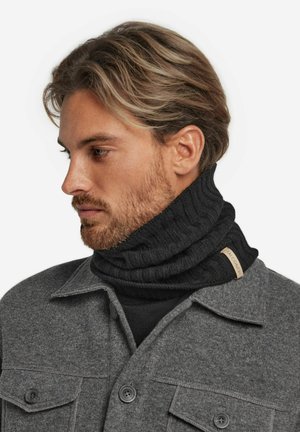 Chauffe-nuque noir en tricot côtelé avec une étiquette tissée, associé à une chemise grise à boutons et une couche de base noire en dessous.