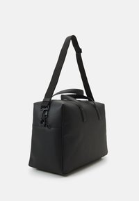 Borsa tote nera in pelle con manici rinforzati, tracolla regolabile e texture liscia. Presenta una chiusura con zip e un design minimale.