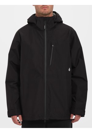 Veste noire imperméable avec une fermeture éclair intégrale, une capuche ajustable et une poche poitrine zippée. Présente un logo sur le côté gauche.