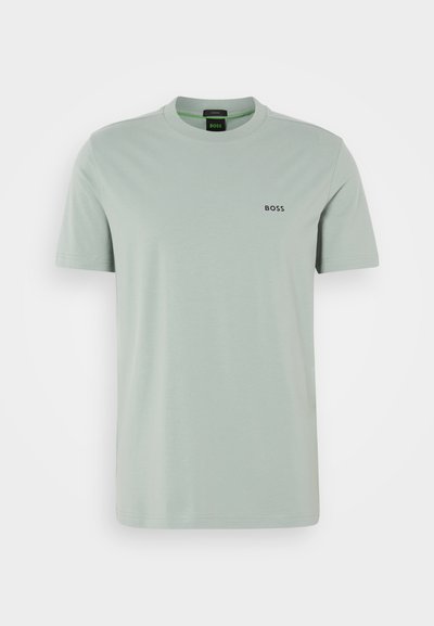 T-shirt en coton vert clair à manches courtes et col rond. Présente un logo noir "BOSS" sur la poitrine. Texture lisse.