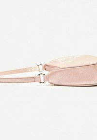 Lyserød stof crossbody taske med en tekstureret overflade, der har et lynlåsrum og blanke sølvhardware detaljer.