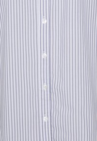 Himmelblau- und weiß gestreifte Hemdbluse mit weichem Baumwollstoff, ausgestattet mit kleinen, transparenten Knöpfen an der Vorderseite.