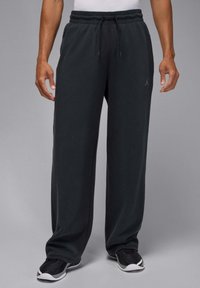 Zwarte, loszittende joggingbroek met een elastische tailleband en verstelbare trekkoord. Voorzien van een klein Jordan-logo aan de linkerkant.