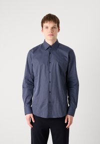 Navyblå stripet skjorte med knapper og pointekrave, lange ermer og knappelukking ved ermene. Stoffet ser glatt ut med vertikale hvite striper.