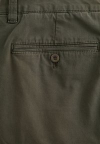 Olivenfarbene Stoffshorts mit glatter Textur, einer Gesäßtasche mit Knopfverschluss und dezenten vertikalen Streifen.
