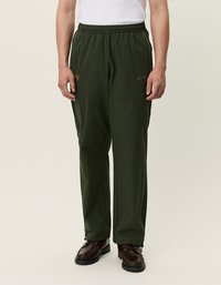 Tmavozelené, štruktúrované polyesterové nohavice s elastickým pásom. Obsahujú biele bočné pruhy a zlaté logo na nohavici.