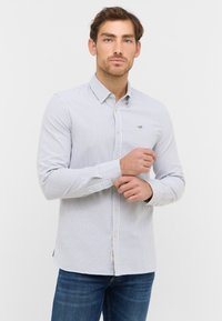 Koszula w paski, zapinana na guziki, w jasnoniebieskim i białym kolorze, z kołnierzykiem, długimi rękawami i wyhaftowanym logo na piersi. Miękka faktura materiału.