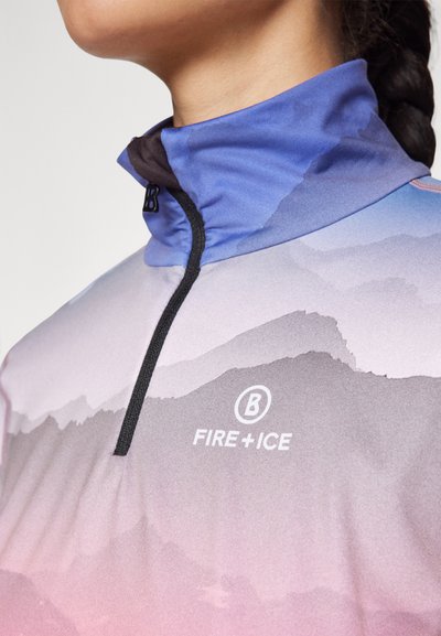 Több színben pompázó, magas nyakú pulóver, hegyekkel díszítve lila, rózsaszín és szürke árnyalatokban. Fél cipzárral és az "FIRE+ICE" logóval rendelkezik.