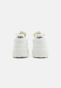 Baskets plateformes blanches avec une finition lisse, dotées de cols rembourrés, de semelles texturées et d'un logo "Buffalo" noir à l'arrière.