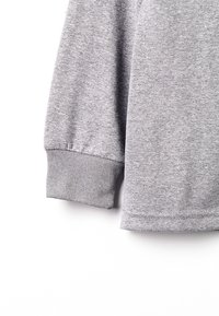 Šedá mikina s vroubkovaným lemem a spodním lemem, vyrobená z měkkého, hladkého materiálu, s ležérním designem a bez viditelných log nebo vzorů.